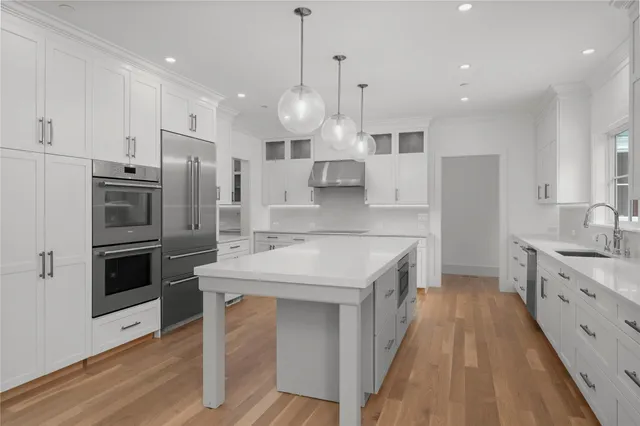 a large kitchen with stainless steel appliances kitchen island granite countertop a stove a sink a refrigerator and a wooden cabinets