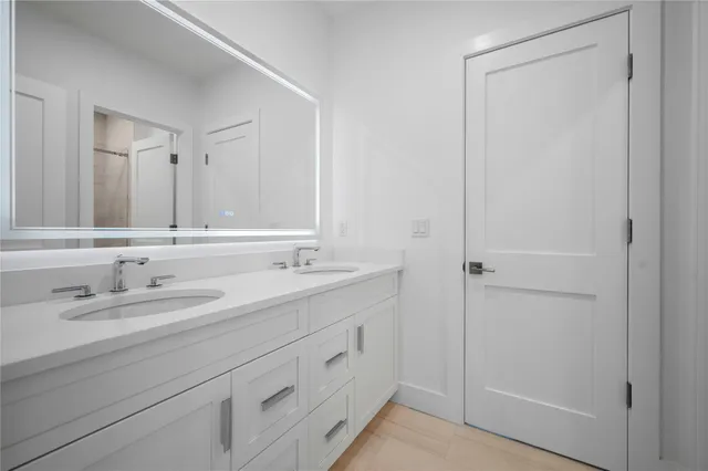 a bathroom with a double vanity sink and a mirror