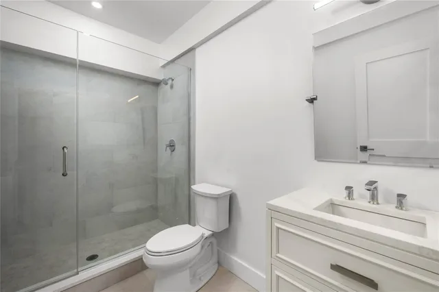 a bathroom with a granite countertop sink a toilet and shower
