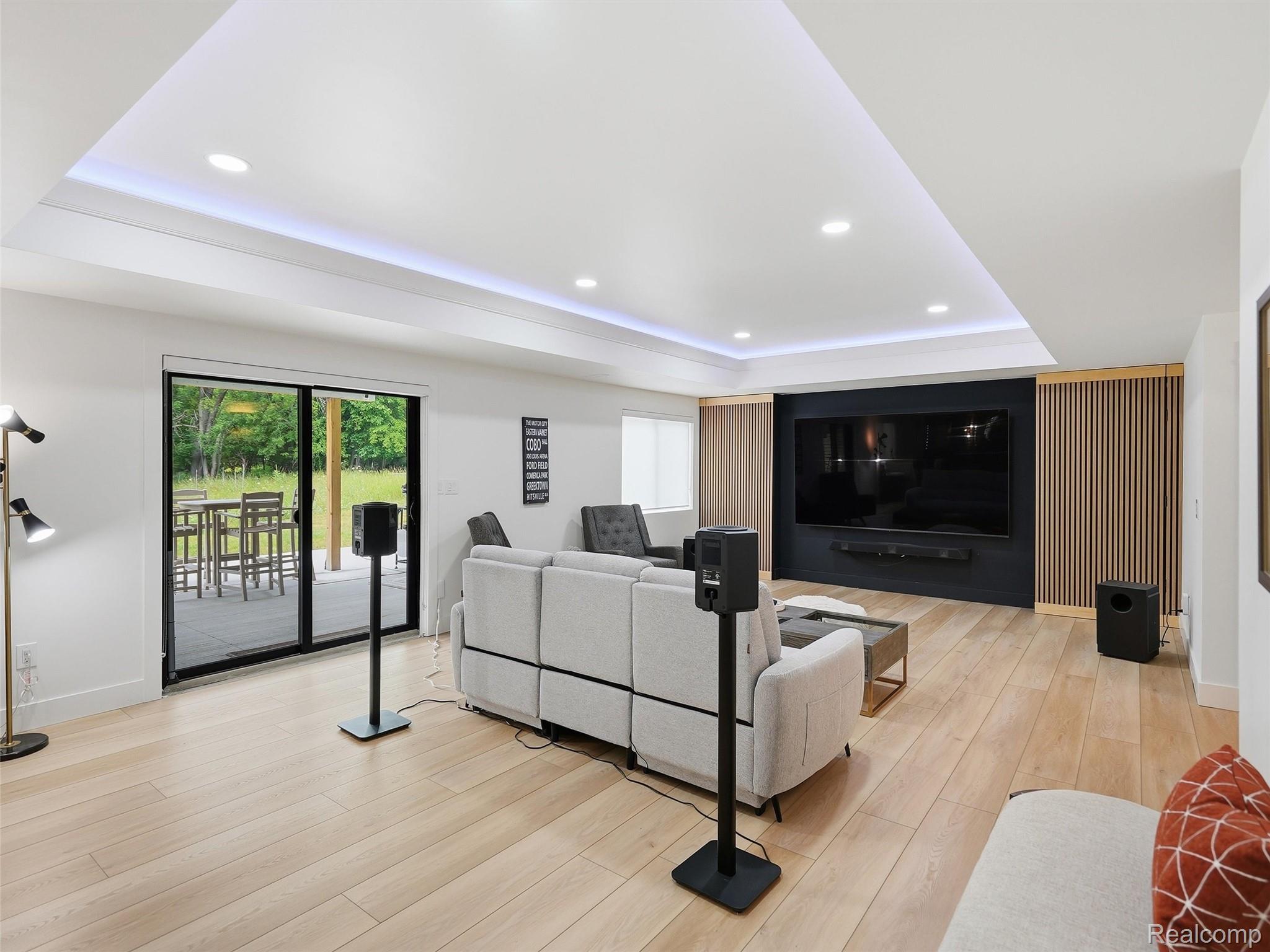 3007 28 Mile Road Washington, MI 48094 - Photo 43 of 69 Spacious entertainment area featuring light wood-finish flooring, recessed lighting, and a tray ceiling with integrated strip lighting