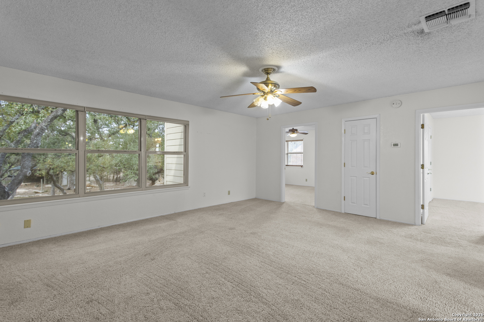 33171 Blanco Road Bulverde, TX 78163 - Photo 26 of 59 an empty room with chandelier fan and windows