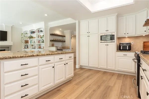 a kitchen with granite countertop white cabinets and a window