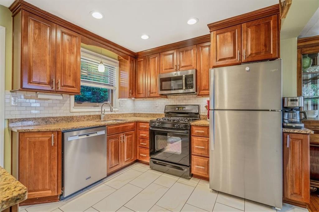 21 Marquette Road Pittsburgh, PA 15229 - Photo 11 of 44 a kitchen with stainless steel appliances granite countertop a refrigerator a stove a sink and a microwave