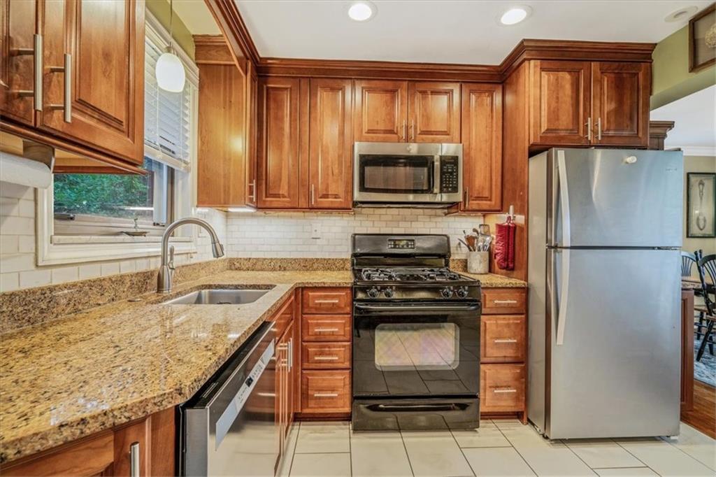 21 Marquette Road Pittsburgh, PA 15229 - Photo 12 of 44 a kitchen with granite countertop a refrigerator stove and microwave