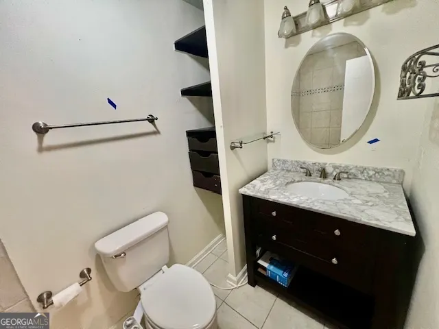 a bathroom with a granite countertop toilet sink and mirror