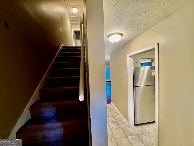 a view of a room with a flat screen tv and chandelier fan