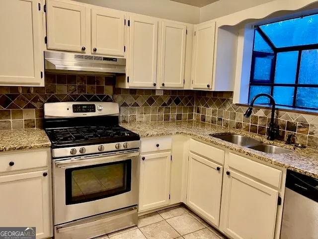 a kitchen with granite countertop white cabinets and white appliances
