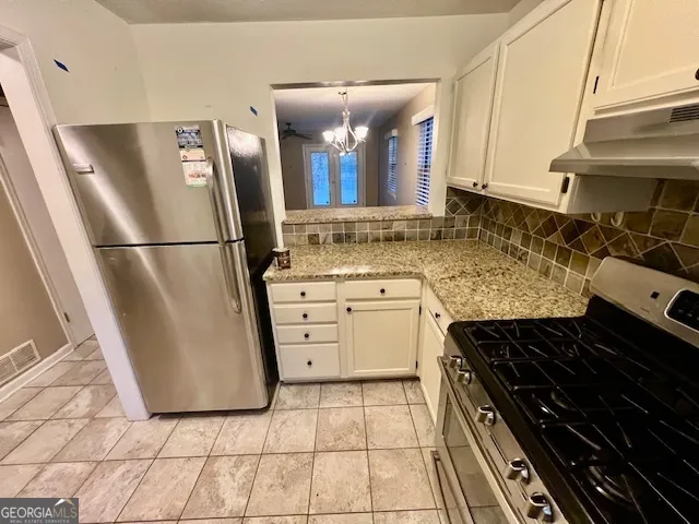 a kitchen with granite countertop a sink a stove and cabinets