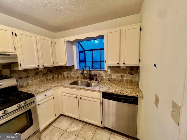 a kitchen with cabinets appliances a sink and a counter top space