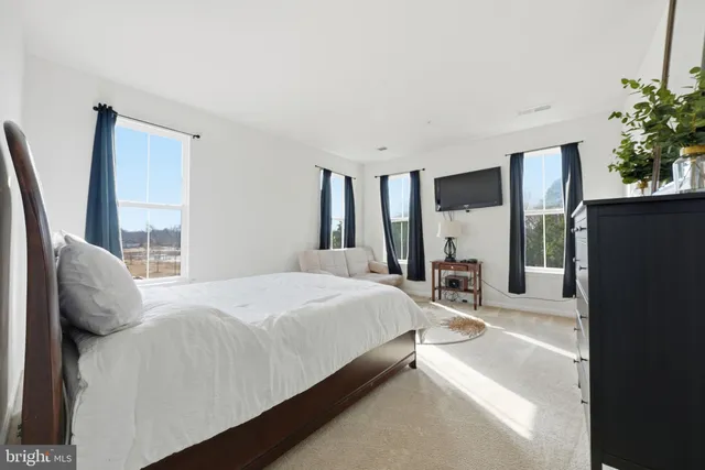 a bedroom with a bed and a large window