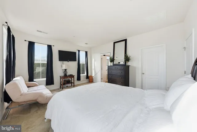 a large bedroom with a bed and large window