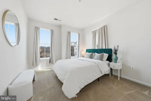 a bedroom with a bed chair and a large window