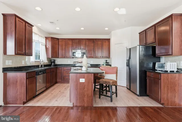 a kitchen with stainless steel appliances wooden floors and wooden cabinets