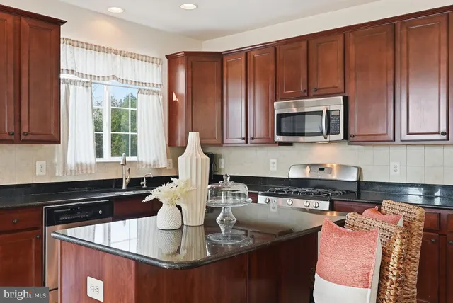 a kitchen with kitchen island granite countertop a sink stove and microwave