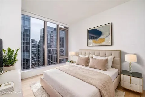 a bedroom with a large bed and a potted plant
