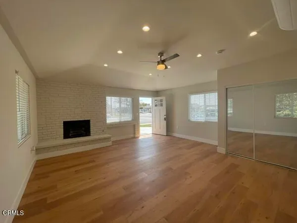 an empty room with windows and fireplace