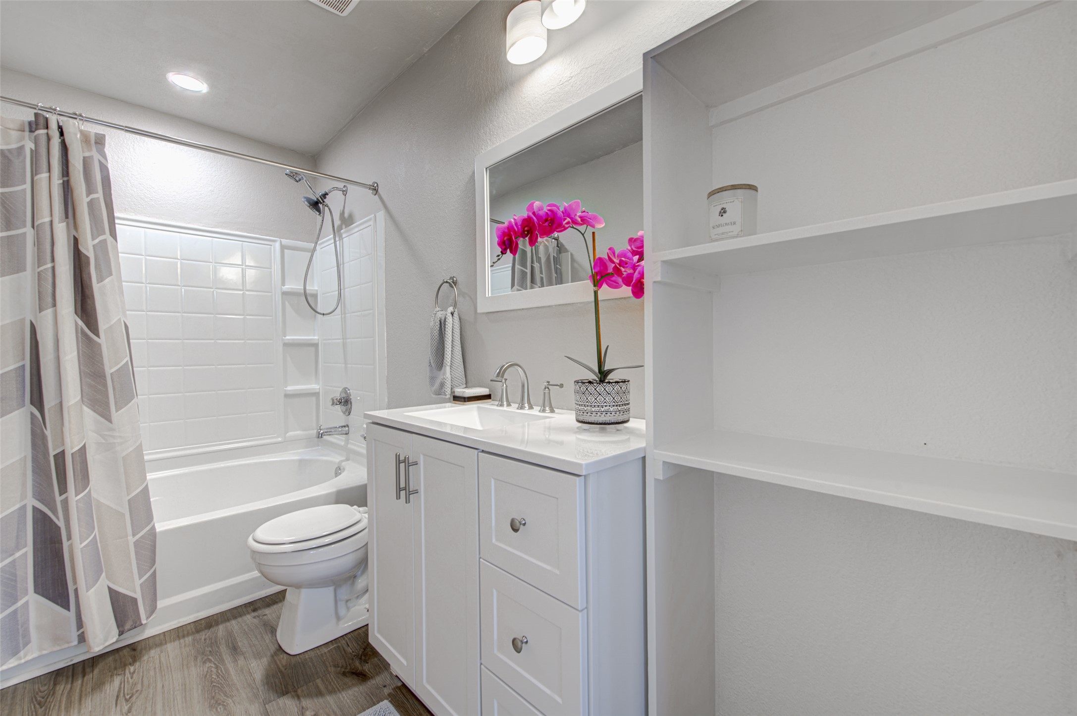 6709 Doyal Drive Austin, TX 78747 - Photo 19 of 22 Bathroom with vanity, dark wood-type flooring, shower / tub combo with curtain, and a textured wall