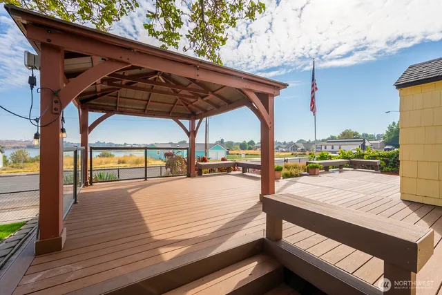 a view of a patio with wooden floor table and chairs