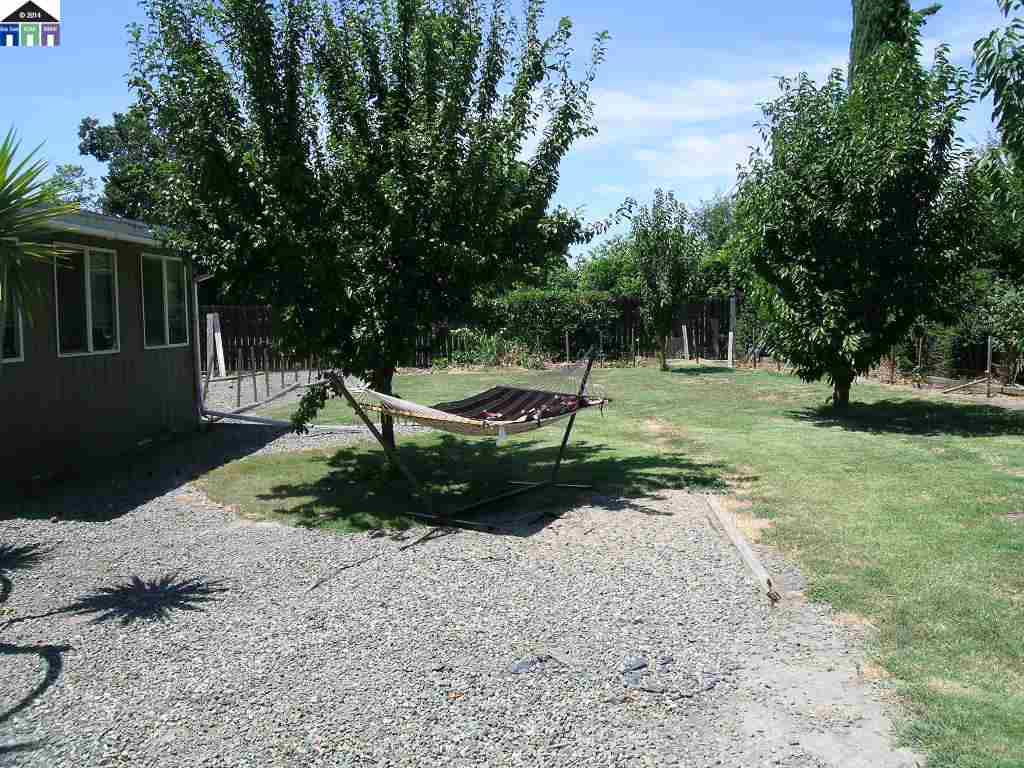 681 Tyler Island Bridge Road Isleton, CA 95641 - Photo 21 of 24 a backyard of a house with barbeque oven table and chairs