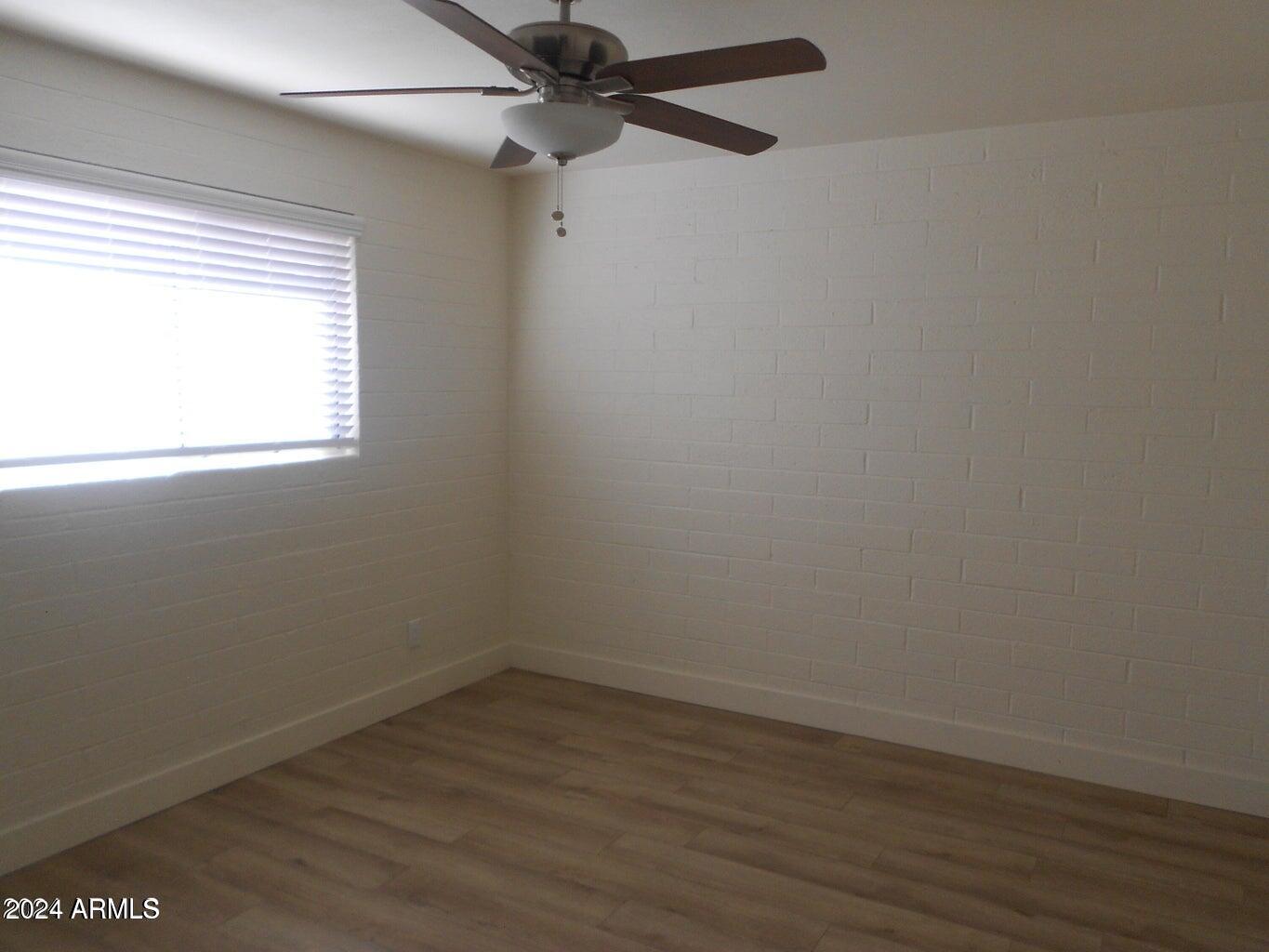 3151 North 36th Street, Unit 5 Phoenix, AZ 85018 - Photo 4 of 13 an empty room with wooden floor fan and windows