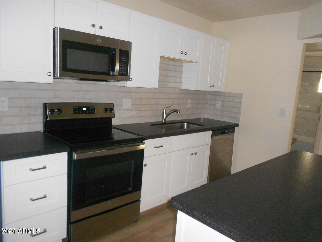 3151 North 36th Street, Unit 5 Phoenix, AZ 85018 - Photo 5 of 13 a kitchen with a stove and a microwave