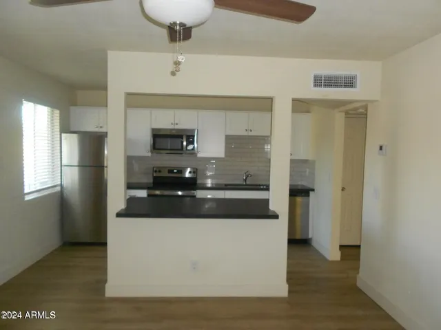 a large kitchen with stainless steel appliances a refrigerator and a stove top oven