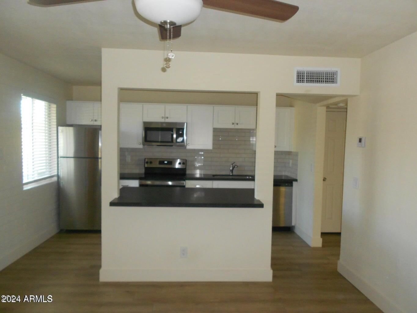 3151 North 36th Street, Unit 5 Phoenix, AZ 85018 - Photo 6 of 13 a large kitchen with stainless steel appliances a refrigerator and a stove top oven