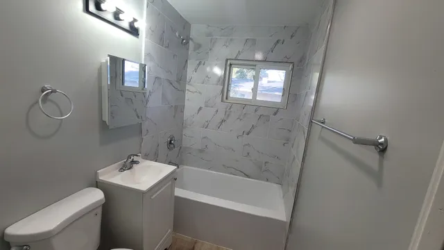 a bathroom with a sink a toilet and shower