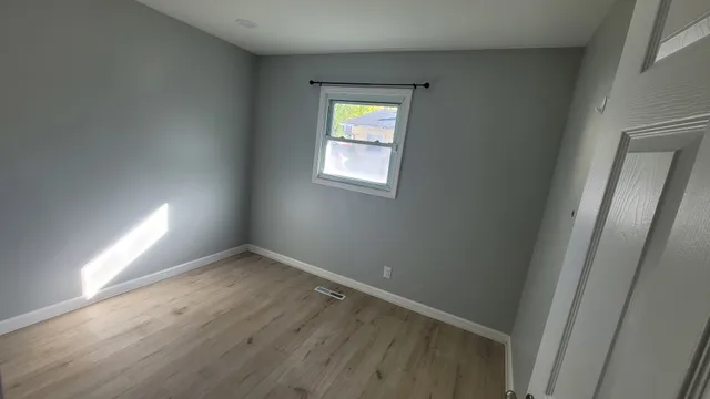 an empty room with windows and closet