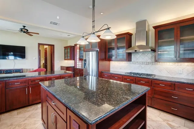 a kitchen with stainless steel appliances granite countertop a stove a sink and a refrigerator