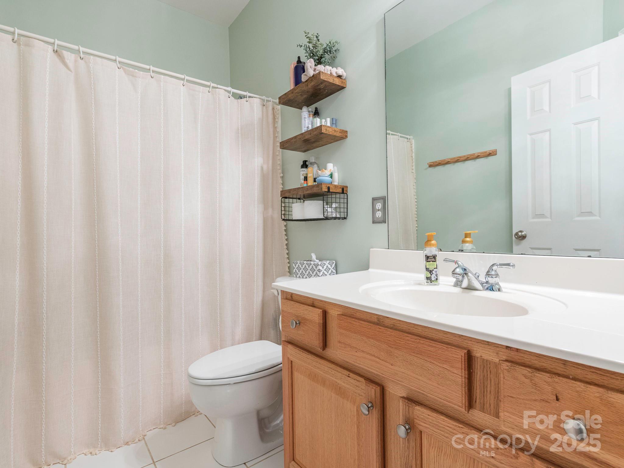 3033 Beech Court Indian Trail, NC 28079 - Photo 22 of 39 a bathroom with a sink a toilet and a mirror