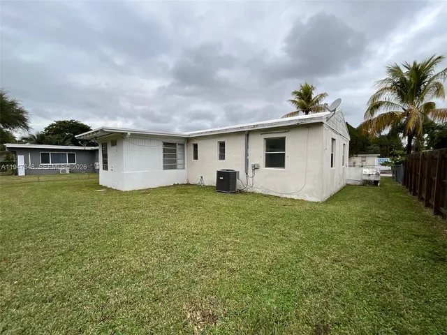 a view of an house with backyard space and balcony