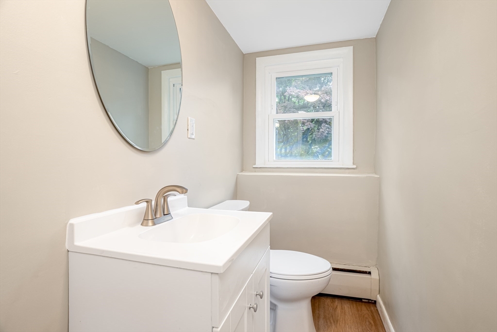 477 Salisbury Street Worcester, MA 01609 - Photo 30 of 42 a bathroom with a toilet a sink a mirror and a window