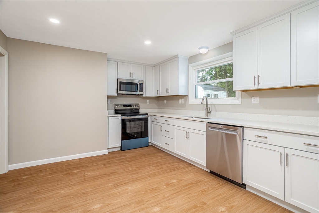 477 Salisbury Street Worcester, MA 01609 - Photo 6 of 42 a kitchen with granite countertop white cabinets and stainless steel appliances