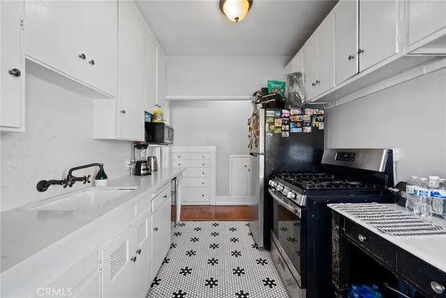 a kitchen with stainless steel appliances a stove a sink and a refrigerator
