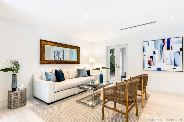 a living room with furniture and a painting on the wall