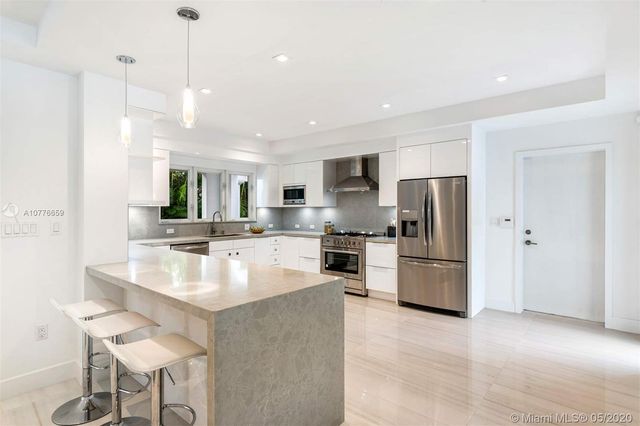a large kitchen with a table chairs refrigerator and a sink