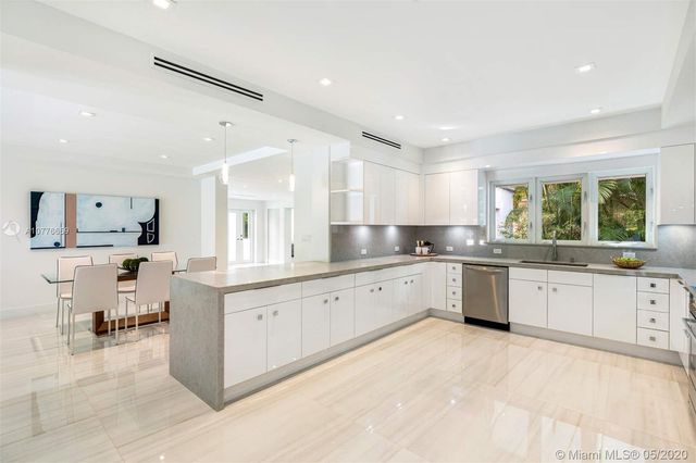 a large white kitchen with cabinets