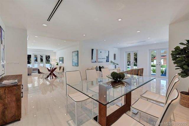 a living room with furniture and a dining table with wooden floor