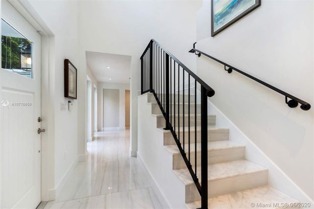 a view of staircase with lots of frames on wall and windows