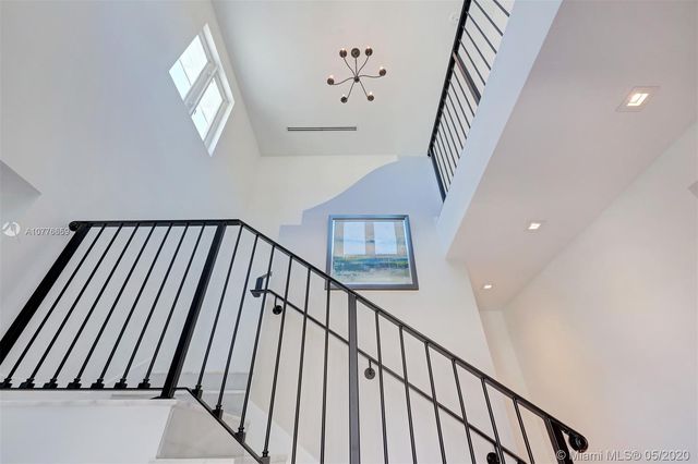 a view of staircase with wooden floor and fan