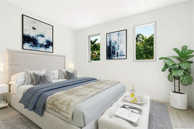 a bedroom with a bed and a potted plant