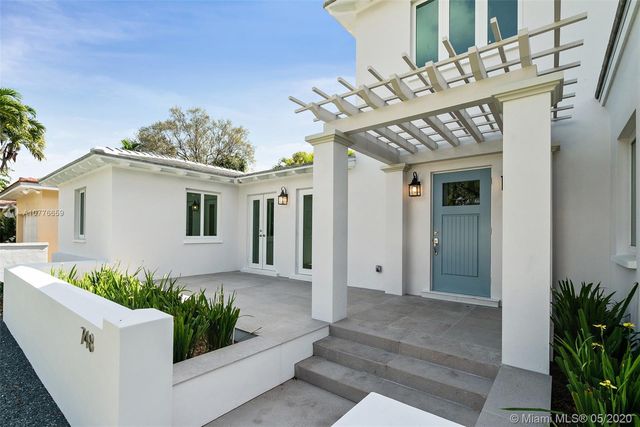 a front view of a house with plants