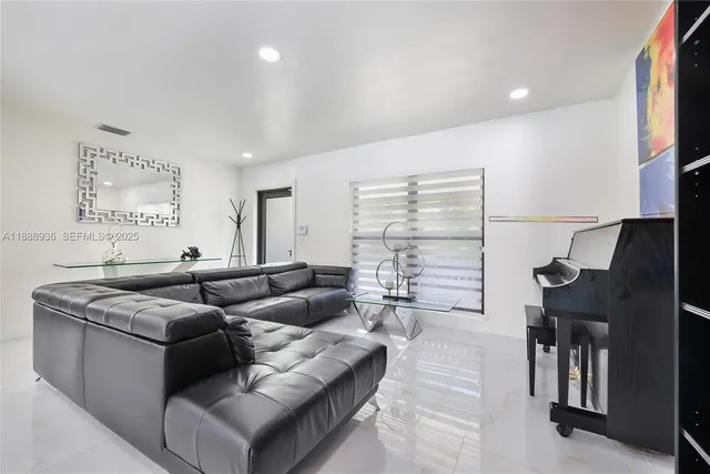 a living room with furniture a fireplace and a chandelier