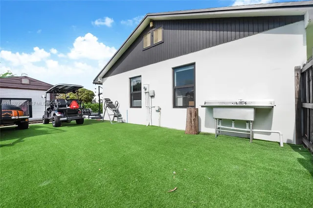 a view of a house with backyard and a garden