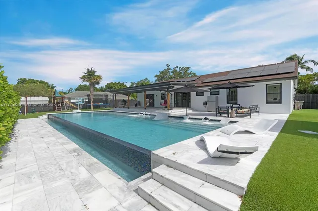 a view of a house with swimming pool and sitting area