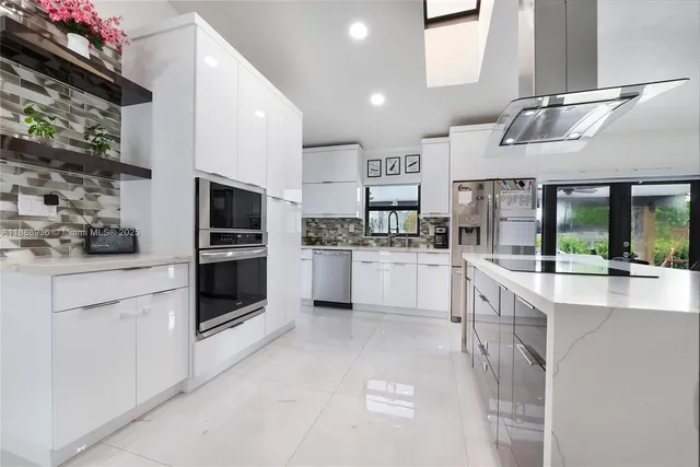 a kitchen with stainless steel appliances kitchen island granite countertop a stove and cabinets