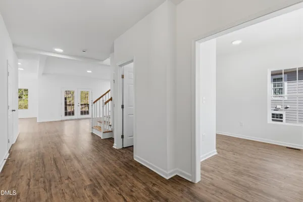 a view of a hallway with wooden floor and windows