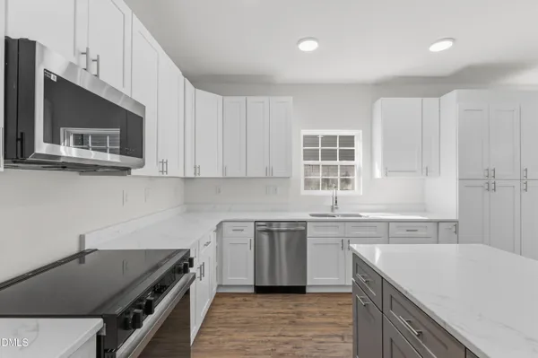 a kitchen with a sink stove top oven and cabinets