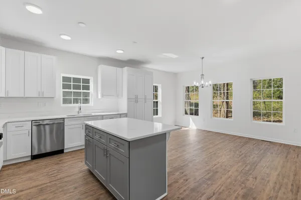 a large kitchen with stainless steel appliances granite countertop a lot of counter space and wooden floors